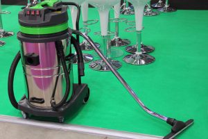 Equipment for automobile service - new chrome electric professional vacuum cleaner for car washes on green background